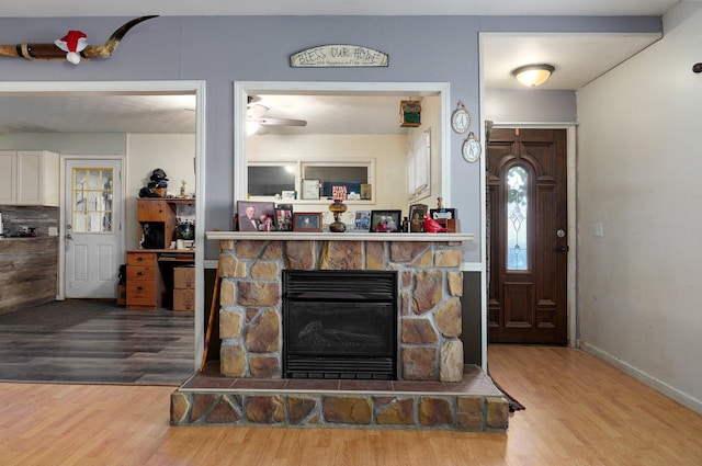 room details with hardwood / wood-style flooring, ceiling fan, and a fireplace