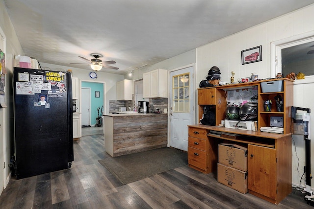 kitchen featuring tasteful backsplash, white cabinetry, black fridge, dark wood-type flooring, and ceiling fan