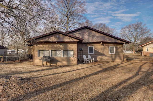 rear view of property featuring a lawn