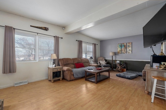 living room featuring light hardwood / wood-style flooring, vaulted ceiling with beams, and a wealth of natural light