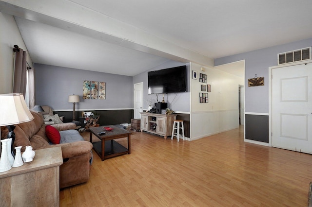 living room with hardwood / wood-style flooring and vaulted ceiling with beams