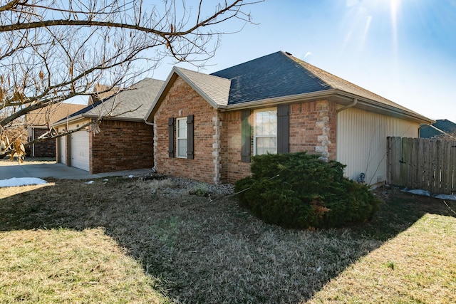 view of side of home featuring a garage and a lawn