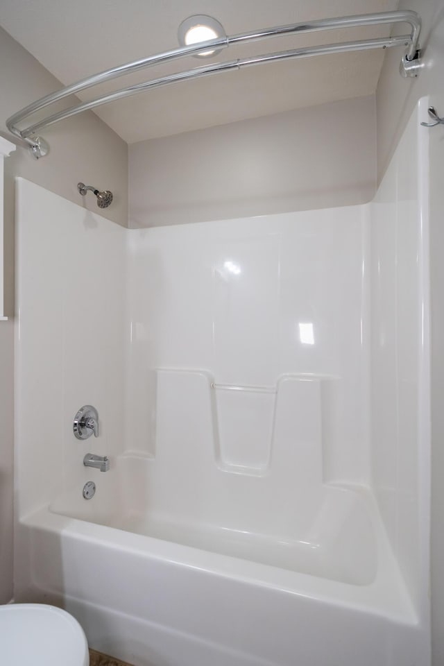 bathroom featuring shower / washtub combination and toilet