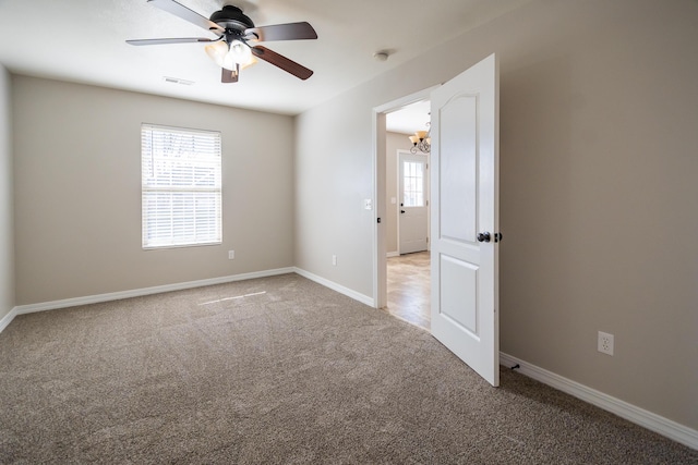 carpeted empty room featuring ceiling fan