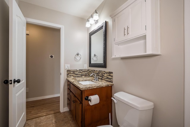 bathroom featuring vanity, backsplash, and toilet