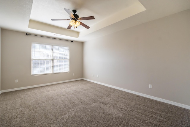 unfurnished room with a tray ceiling, carpet floors, and ceiling fan