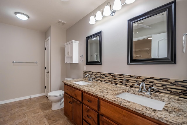 bathroom featuring tasteful backsplash, vanity, and toilet