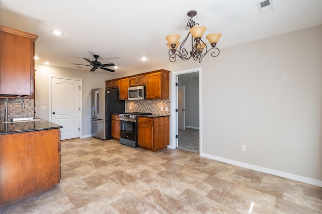 kitchen featuring ceiling fan with notable chandelier, decorative light fixtures, sink, backsplash, and stainless steel appliances