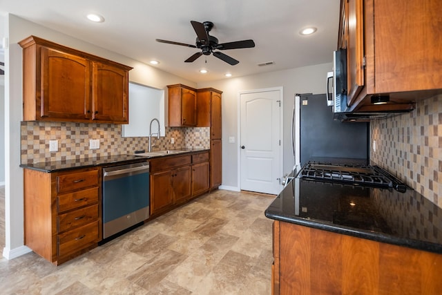 kitchen featuring stainless steel appliances, tasteful backsplash, sink, and dark stone counters