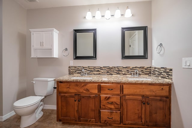 bathroom featuring vanity, toilet, and backsplash