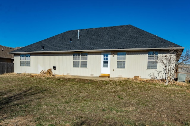 rear view of house with cooling unit and a yard