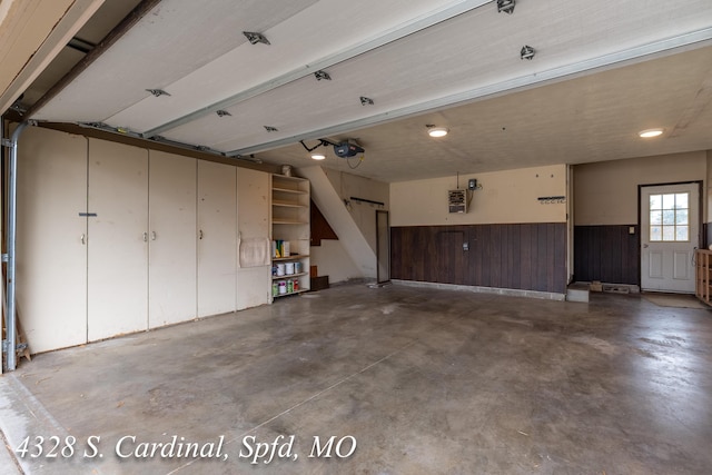 garage featuring wood walls and a garage door opener