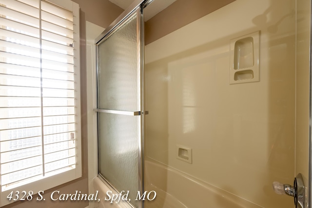 bathroom featuring bath / shower combo with glass door