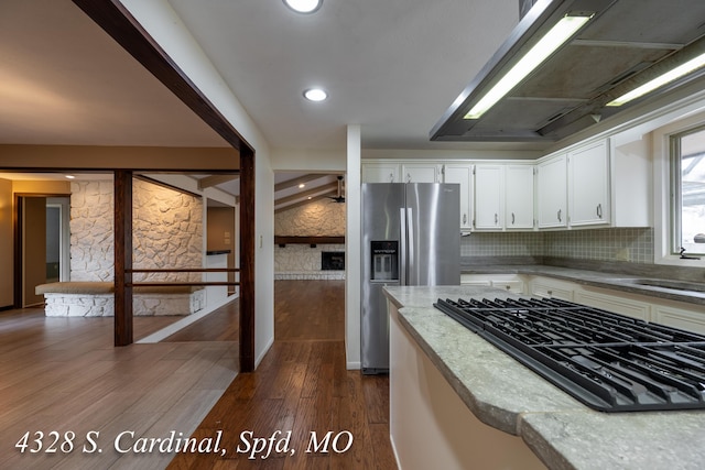 kitchen featuring stainless steel fridge, dark hardwood / wood-style flooring, white cabinets, black gas stovetop, and decorative backsplash