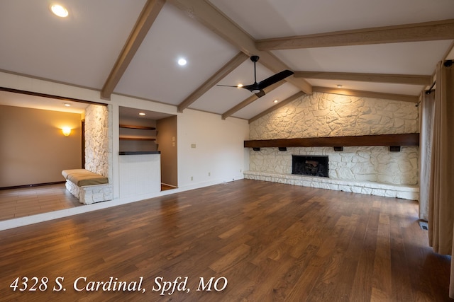 unfurnished living room featuring ceiling fan, a stone fireplace, vaulted ceiling with beams, and wood-type flooring