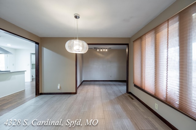 unfurnished dining area featuring light wood-type flooring