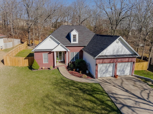 view of front of property with a front lawn, driveway, fence, a garage, and brick siding