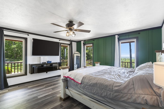 bedroom with ceiling fan, dark wood-type flooring, multiple windows, and access to exterior