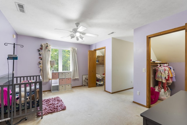 carpeted bedroom with a textured ceiling and ceiling fan