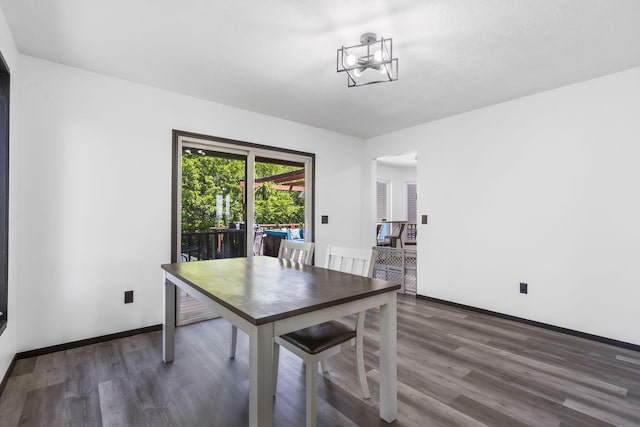 unfurnished dining area with an inviting chandelier and dark hardwood / wood-style floors