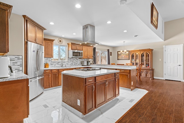 kitchen with appliances with stainless steel finishes, island range hood, a kitchen island, kitchen peninsula, and pendant lighting