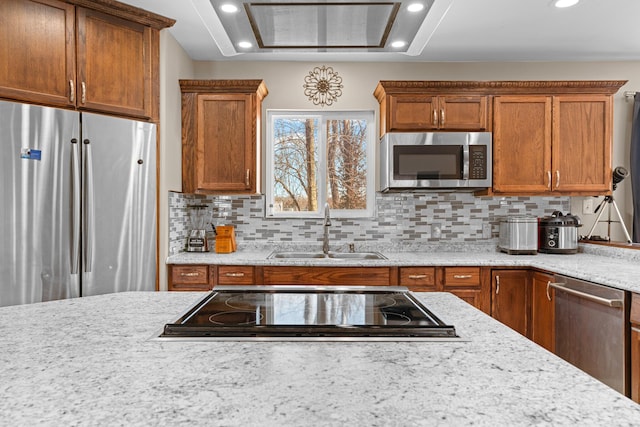 kitchen featuring sink, light stone counters, tasteful backsplash, and appliances with stainless steel finishes