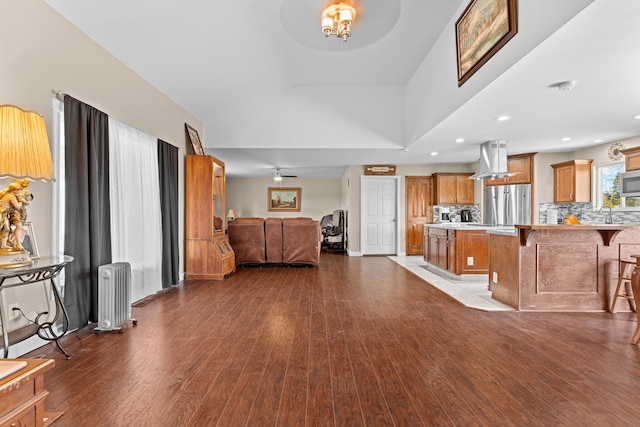 living room featuring light hardwood / wood-style floors, radiator heating unit, and high vaulted ceiling