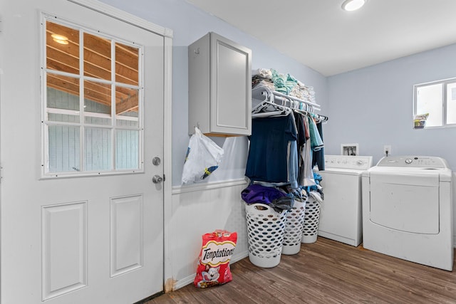 laundry room featuring hardwood / wood-style floors, cabinets, and washer and dryer