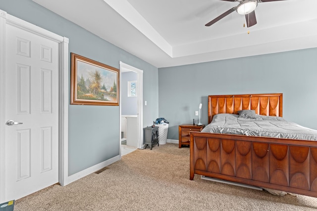 bedroom featuring ceiling fan, light colored carpet, and connected bathroom