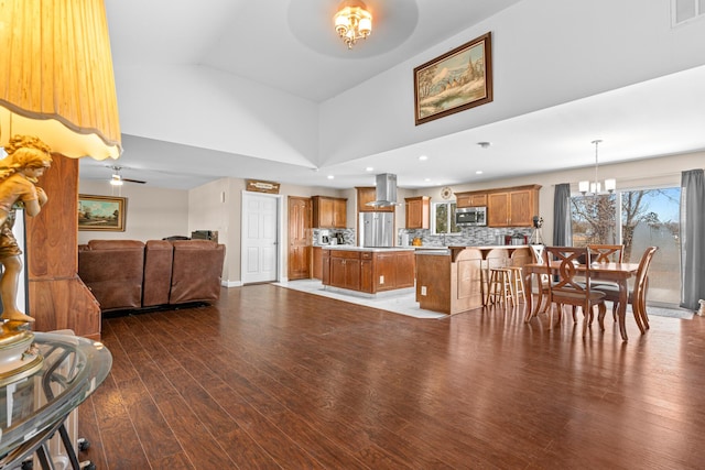 living room with high vaulted ceiling, dark wood-type flooring, and ceiling fan with notable chandelier