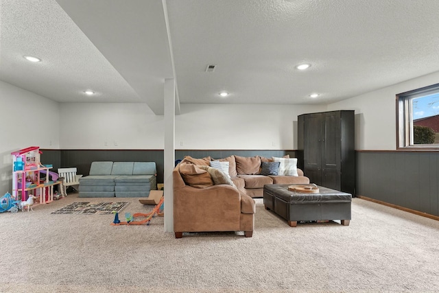 living room featuring a textured ceiling and wooden walls