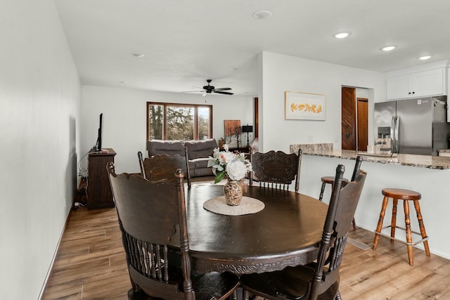 dining area with light hardwood / wood-style flooring and ceiling fan