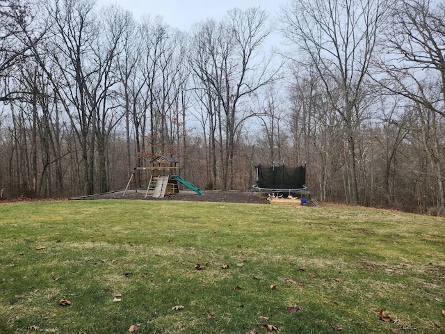 view of yard featuring a playground and a trampoline