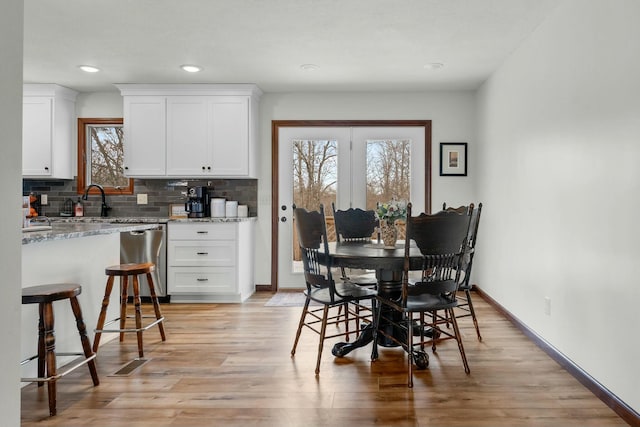 dining area with light hardwood / wood-style floors and sink