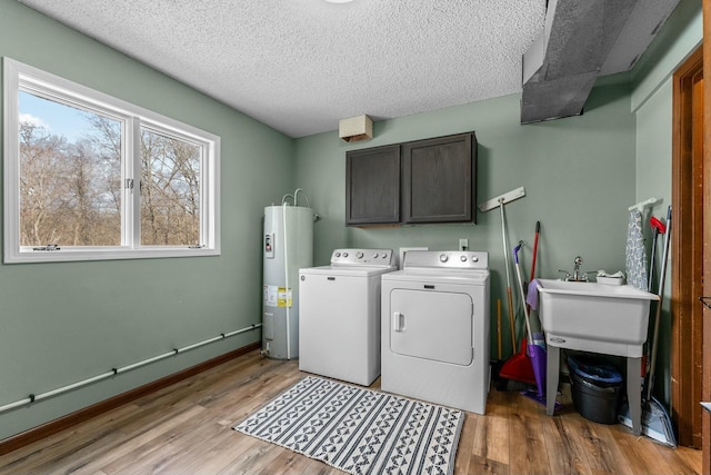 washroom with cabinets, separate washer and dryer, water heater, and light hardwood / wood-style flooring