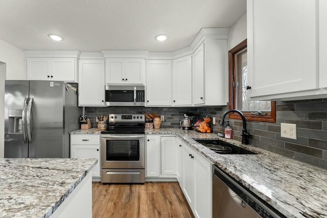 kitchen featuring sink, white cabinetry, light hardwood / wood-style flooring, and appliances with stainless steel finishes