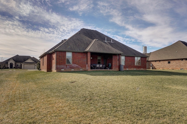 rear view of house featuring a garage and a yard