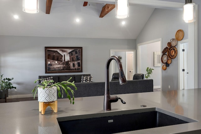 kitchen with ceiling fan, sink, hanging light fixtures, and lofted ceiling with beams