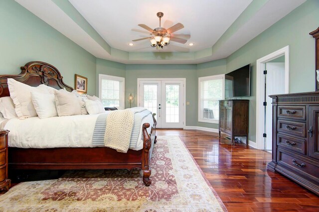 bedroom with ceiling fan, access to exterior, french doors, dark hardwood / wood-style flooring, and a raised ceiling