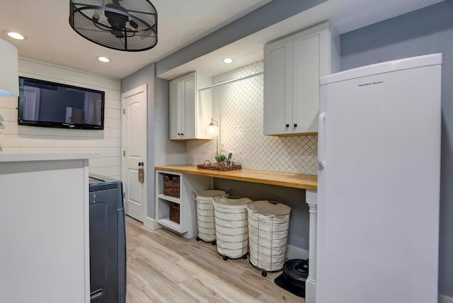 kitchen featuring butcher block counters, white cabinets, decorative backsplash, white fridge, and light wood-type flooring