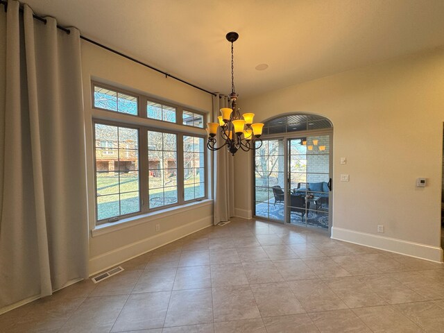 unfurnished dining area with a notable chandelier