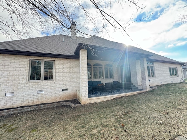 view of side of home with a yard and a patio