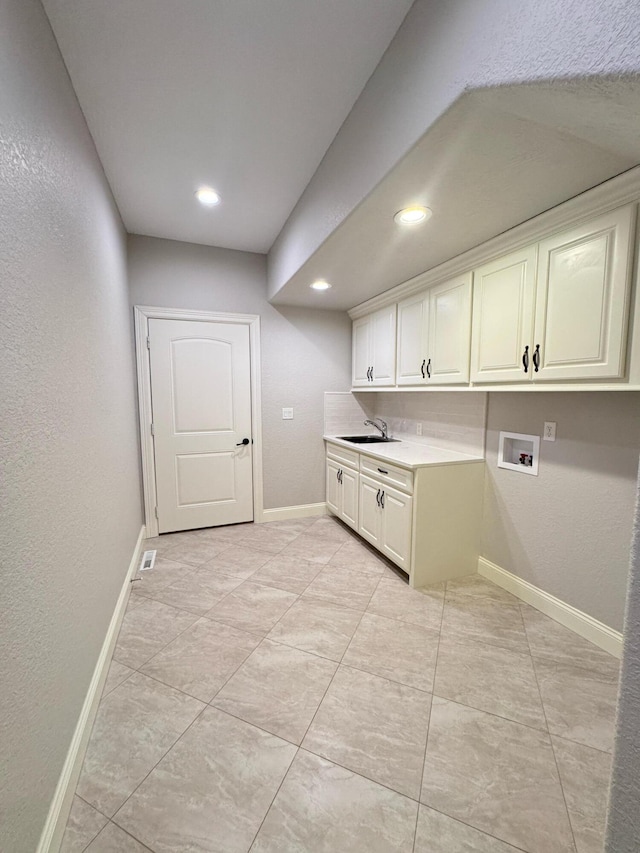 laundry room with washer hookup, cabinets, and sink