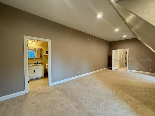 interior space with light colored carpet and vaulted ceiling