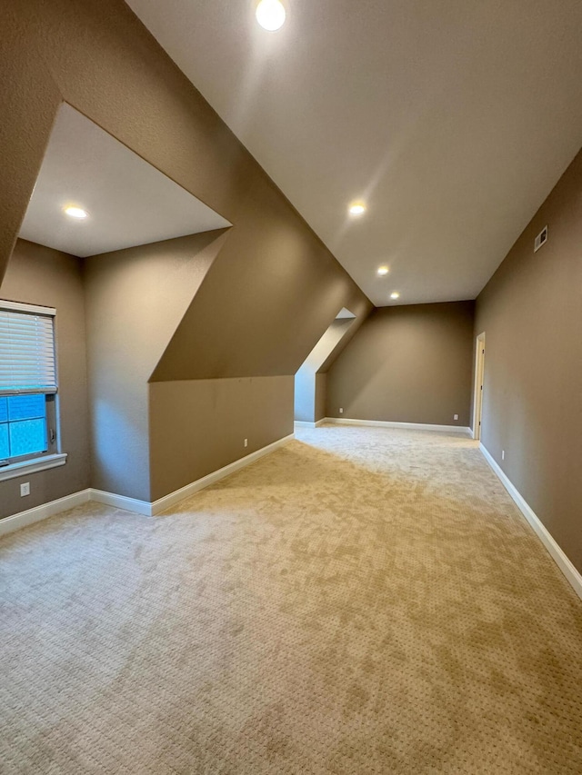 additional living space with vaulted ceiling and carpet flooring