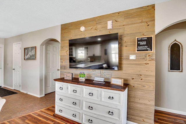 interior space featuring white cabinets, wood walls, dark wood-type flooring, and butcher block counters