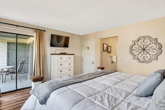 bedroom with hardwood / wood-style floors and access to outside