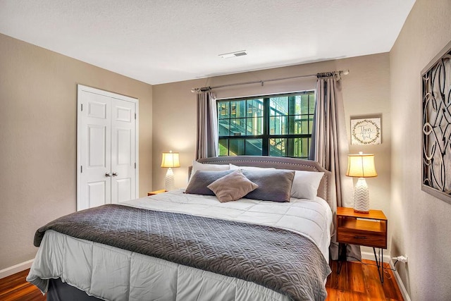 bedroom featuring dark hardwood / wood-style flooring and a closet