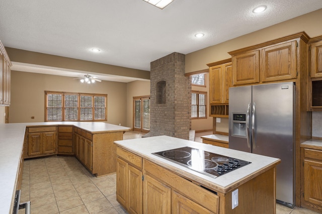 kitchen with ceiling fan, stainless steel refrigerator with ice dispenser, electric stovetop, a kitchen island, and kitchen peninsula