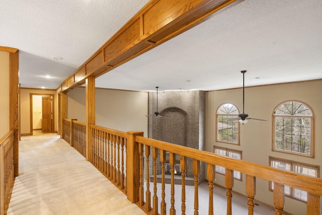 corridor with light colored carpet and a textured ceiling